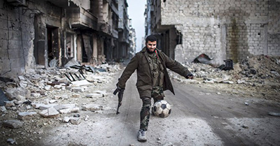 un miliciano juega entre la destrucion en siria