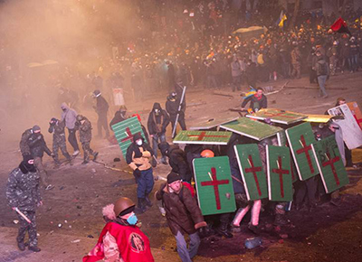 manifestantes levantan los escudos de la policia