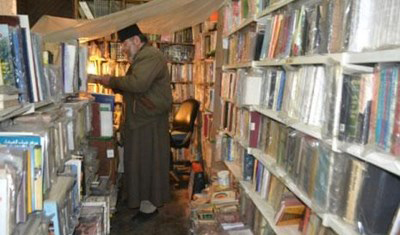 padre ibrahim suruj en su biblioteca antes de ser incendiada
