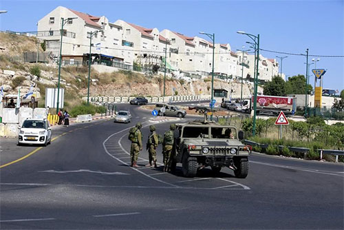 Soldados israelíes vigilan la entrada de la colonia de Kiriat Arbá