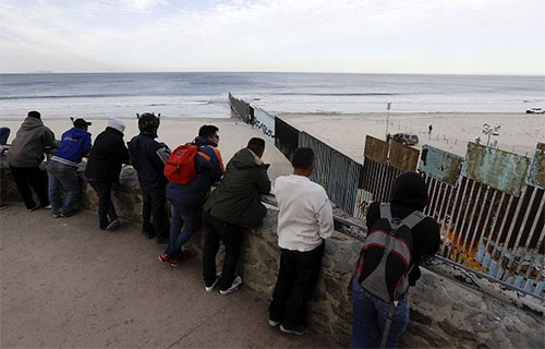 migrantes observan la frontera de Estados Unidos